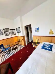 Schalke Themen -Budget Zimmer Retro-Art Hotel Lünen mit signiertem Neuer Trikot aus seiner Schalker Zeit, Wimpel signiert, Kissen, Bilder, Bett, Sessel im Retro Art Hotel Lünen